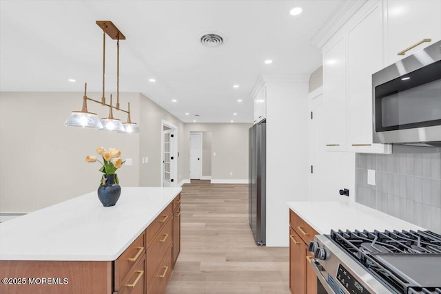6 Fairfield Rd, Toms River, NJ 08757 - kitchen featuring appliances with stainless steel finishes, white cabinets, decorative backsplash, light wood finished floors, and light countertops