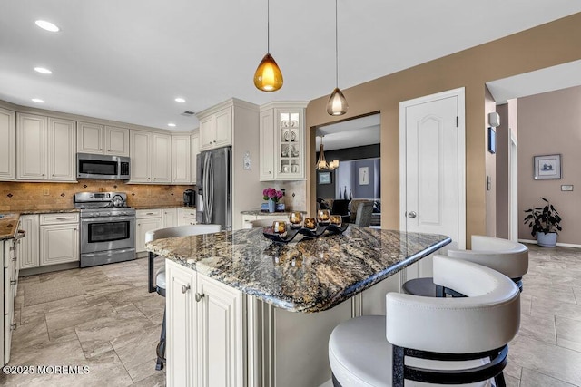 32 Tilton Rd, Brick, NJ 08723 - kitchen with stainless steel appliances, a kitchen bar, backsplash, a center island, and dark stone countertops