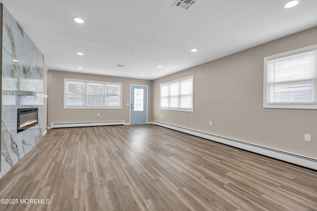 171 Biabou Dr, Toms River, NJ 08757 - unfurnished living room featuring a baseboard radiator, light wood-style flooring, recessed lighting, baseboard heating, and a large fireplace