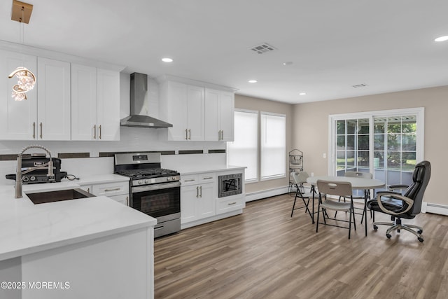 171 Biabou Dr, Toms River, NJ 08757 - kitchen with wall chimney exhaust hood, stainless steel appliances, light wood finished floors, white cabinetry, and baseboard heating