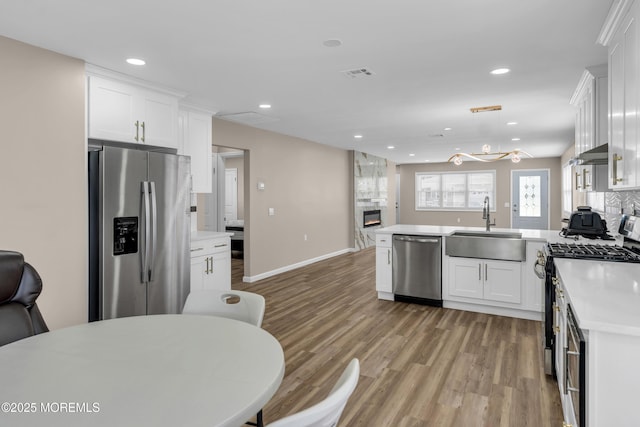 171 Biabou Dr, Toms River, NJ 08757 - kitchen featuring stainless steel appliances, light wood finished floors, a peninsula, white cabinetry, and light countertops