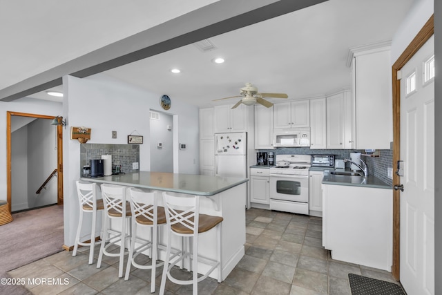 2400 Ocean Front, Lavallette, NJ 08735 - kitchen featuring white appliances, a peninsula, white cabinetry, tasteful backsplash, and recessed lighting