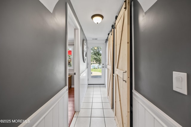 41 Alan Ter, Howell, NJ 07731 - hallway featuring a barn door, light tile patterned flooring, and a wainscoted wall