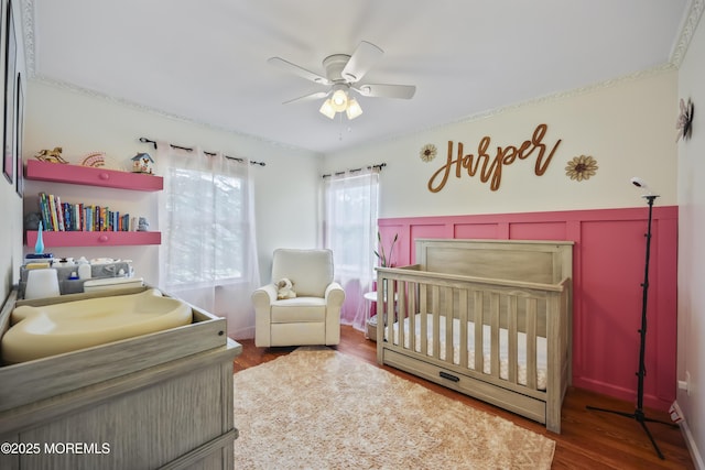 41 Alan Ter, Howell, NJ 07731 - bedroom with a crib, wood finished floors, a wainscoted wall, a ceiling fan, and a decorative wall