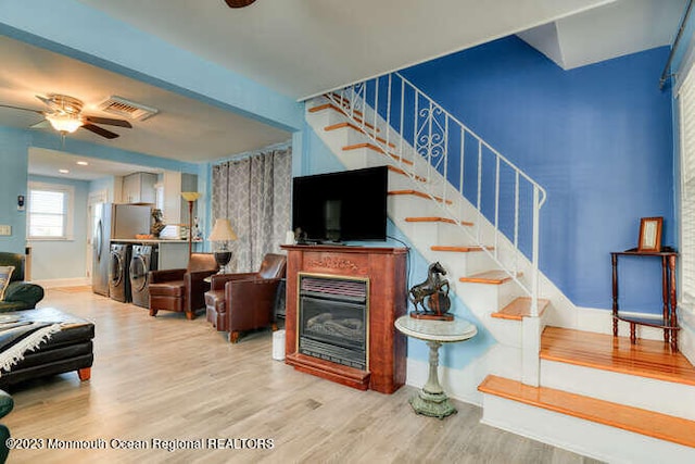63 Asbury Ave, Ocean Grove, NJ 07756 - living area featuring washer and dryer, stairway, wood finished floors, a ceiling fan, and a glass covered fireplace
