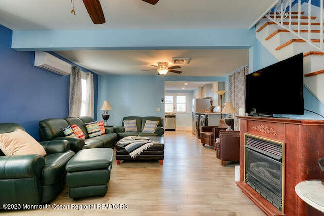 63 Asbury Ave, Ocean Grove, NJ 07756 - living room featuring a ceiling fan, a wall mounted AC, a glass covered fireplace, stairway, and wood finished floors