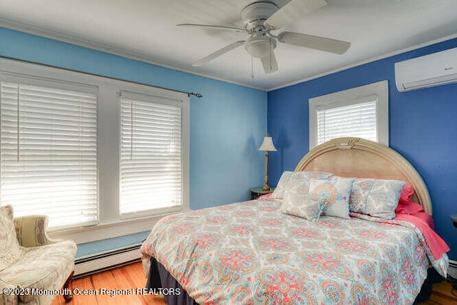 63 Asbury Ave, Ocean Grove, NJ 07756 - bedroom with a baseboard radiator, an AC wall unit, wood finished floors, a ceiling fan, and crown molding