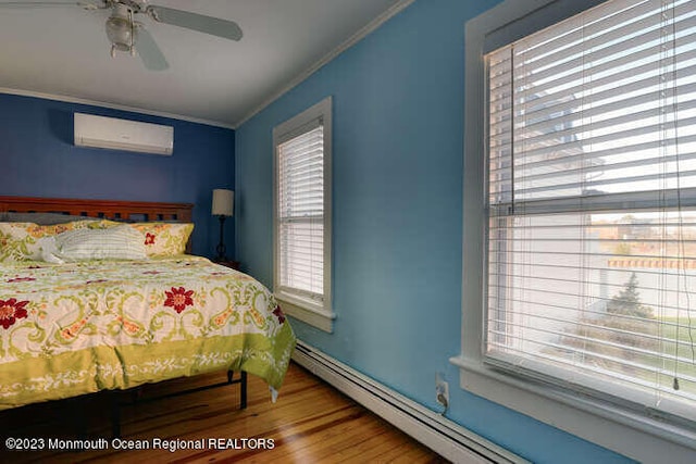 63 Asbury Ave, Ocean Grove, NJ 07756 - bedroom with a wall mounted AC, crown molding, multiple windows, wood finished floors, and a baseboard radiator