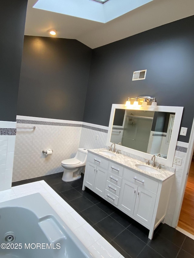 7 Erte Pl, Marlboro, NJ 07746 - full bath with tile walls, tile patterned flooring, a skylight, double vanity, and wainscoting