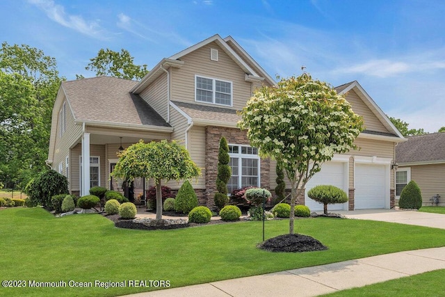 25 Merion Ln, Jackson, NJ 08527 - view of front facade featuring driveway, a front yard, stone siding, and an attached garage