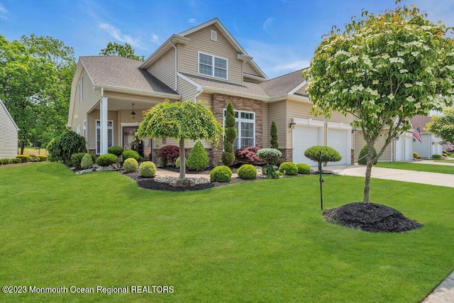 25 Merion Ln, Jackson, NJ 08527 - view of front of property featuring a front lawn, an attached garage, stone siding, concrete driveway, and a shingled roof