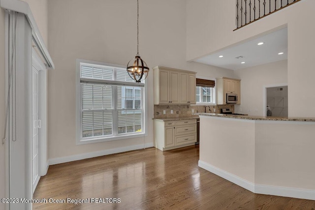 25 Merion Ln, Jackson, NJ 08527 - kitchen with cream cabinetry, a towering ceiling, a chandelier, light wood-type flooring, and appliances with stainless steel finishes