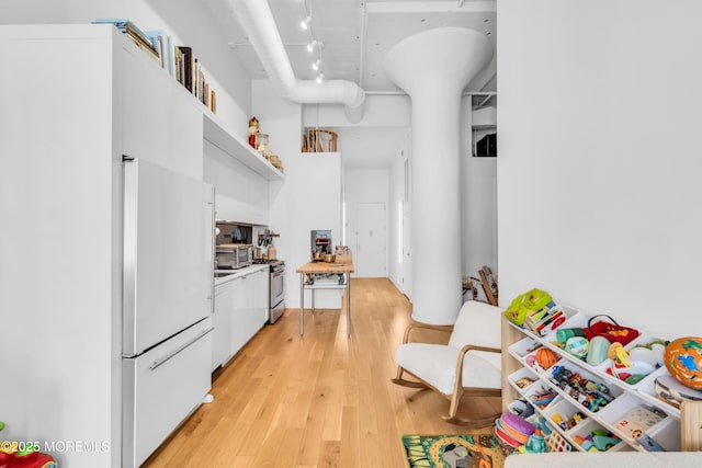50 Dey St Unit 434, Jersey City, NJ 07306 - kitchen with high end fridge, white cabinets, open shelves, light wood-style floors, and stainless steel stove