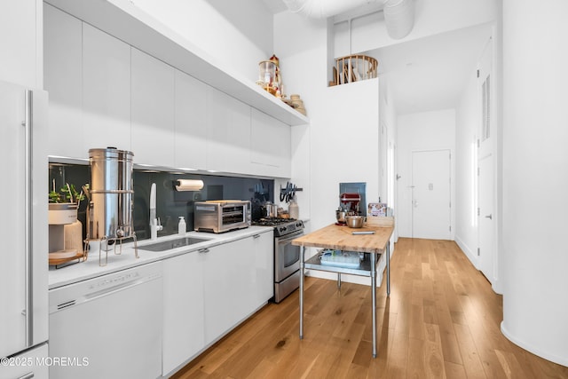 50 Dey St Unit 434, Jersey City, NJ 07306 - kitchen with white appliances, white cabinets, open shelves, light wood finished floors, and a towering ceiling
