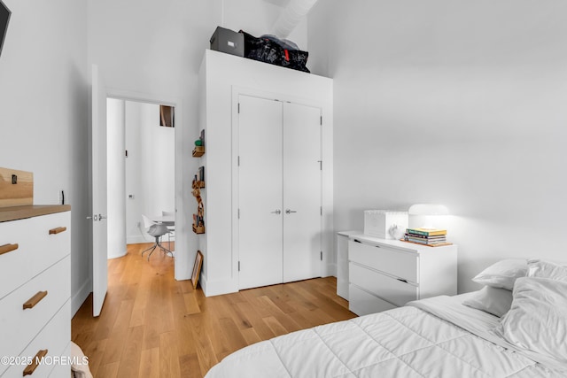 50 Dey St Unit 434, Jersey City, NJ 07306 - bedroom featuring light wood-style floors, a closet, and a towering ceiling