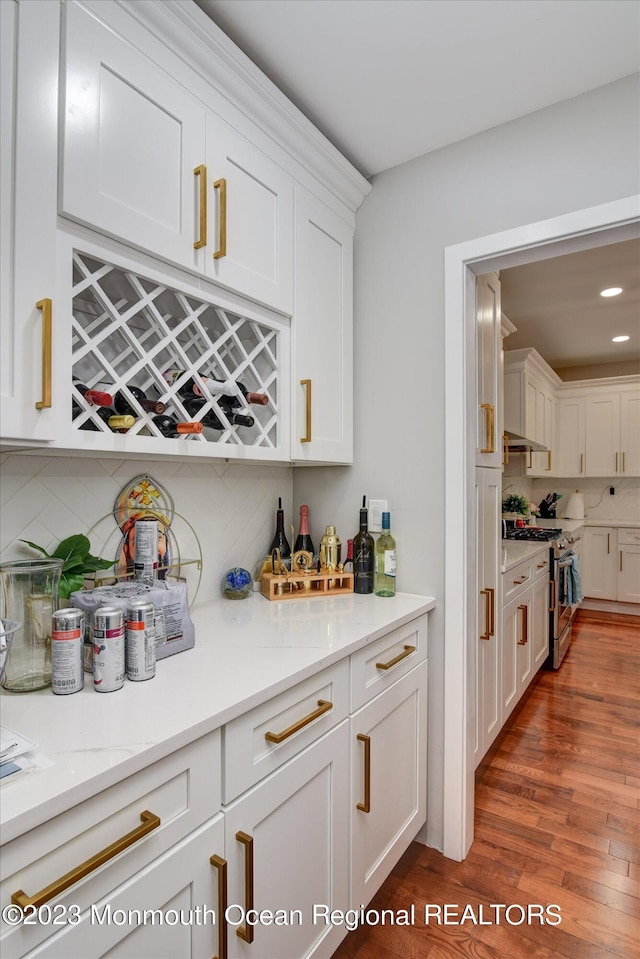 767 Hemlock Rd, Union, NJ 07083 - indoor dry bar with stainless steel gas range oven, decorative backsplash, recessed lighting, wood finished floors, and wall chimney exhaust hood