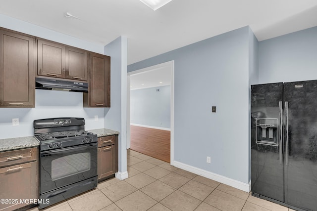 25 Rockefeller Dr, Lakewood, NJ 08701 - kitchen featuring black appliances, under cabinet range hood, dark brown cabinetry, light tile patterned flooring, and light stone counters