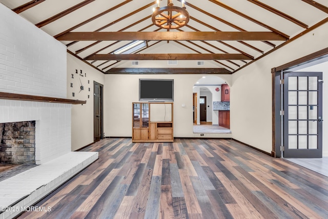 215 Sunset Ln, Howell, NJ 07731 - unfurnished living room featuring arched walkways, wood finished floors, and a brick fireplace