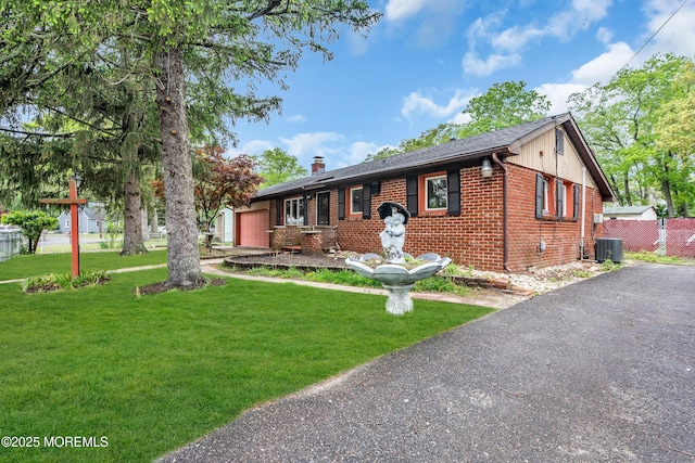 215 Sunset Ln, Howell, NJ 07731 - view of front facade with an attached garage, brick siding, a front lawn, and a chimney