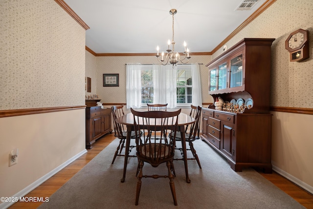 446 Steuben Ave, Forked River, NJ 08731 - dining area with wallpapered walls, ornamental molding, a chandelier, wood finished floors, and wainscoting