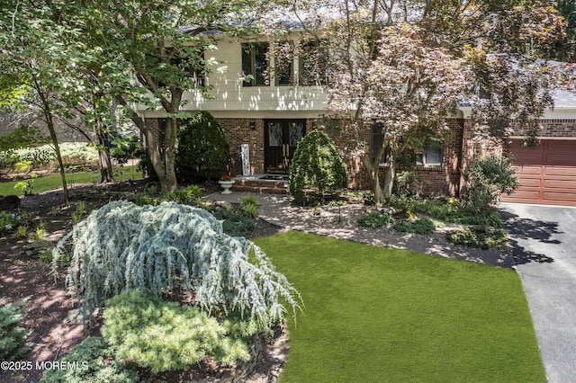 27 Darby Rd, East Brunswick, NJ 08816 - view of front facade with brick siding, an attached garage, driveway, and a front yard