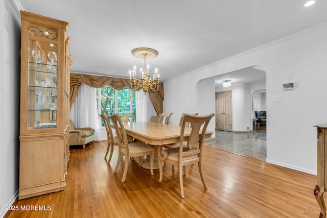 27 Darby Rd, East Brunswick, NJ 08816 - dining room with arched walkways, light wood-type flooring, a chandelier, and crown molding