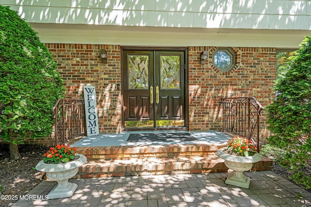27 Darby Rd, East Brunswick, NJ 08816 - doorway to property with brick siding, a porch, and french doors