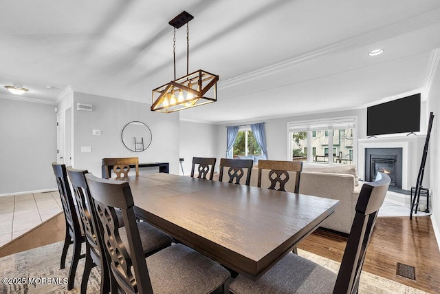 203 Muskflower Ct, Toms River, NJ 08753 - dining space with ornamental molding, a glass covered fireplace, and light wood-type flooring