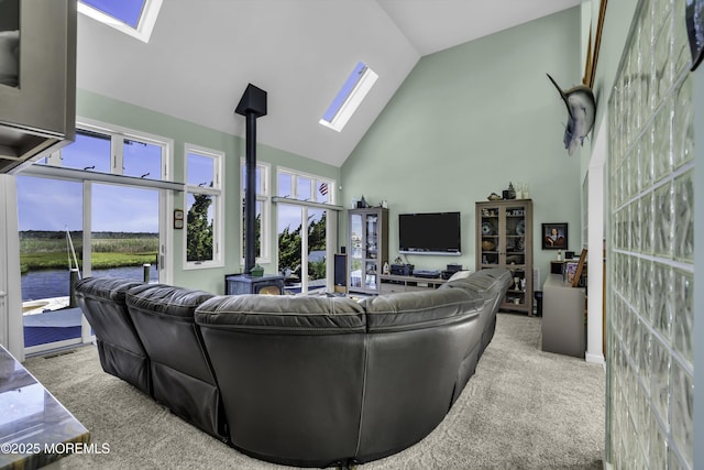 1030 Montauk Dr, Forked River, NJ 08731 - carpeted living room featuring a skylight, high vaulted ceiling, a wood stove, and a water view
