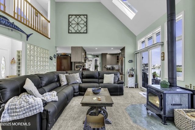 1030 Montauk Dr, Forked River, NJ 08731 - living room featuring a wood stove, high vaulted ceiling, a skylight, and light colored carpet