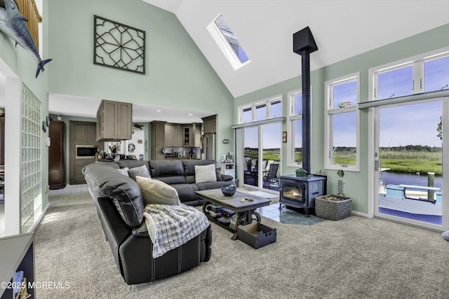 1030 Montauk Dr, Forked River, NJ 08731 - living area with a wood stove, high vaulted ceiling, plenty of natural light, light carpet, and a water view