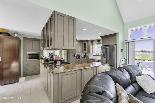 1030 Montauk Dr, Forked River, NJ 08731 - kitchen featuring stainless steel appliances, open floor plan, glass insert cabinets, light stone counters, and tasteful backsplash
