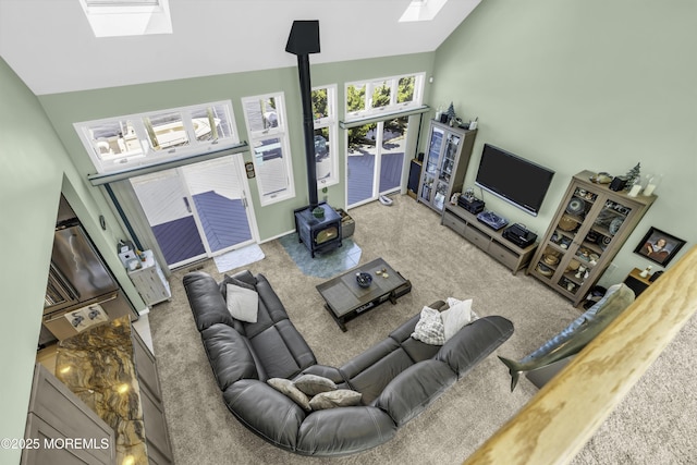 1030 Montauk Dr, Forked River, NJ 08731 - living room with a skylight, a wood stove, carpet, and high vaulted ceiling