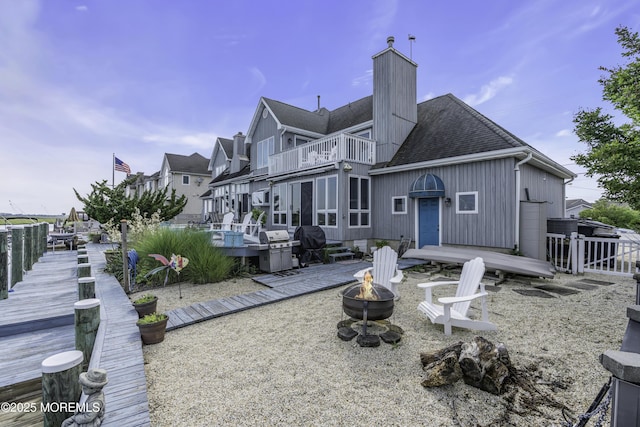 1030 Montauk Dr, Forked River, NJ 08731 - back of house with a balcony, an outdoor fire pit, a chimney, a deck, and a shingled roof