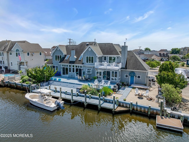 1030 Montauk Dr, Forked River, NJ 08731 - rear view of property with a balcony, board and batten siding, a shingled roof, a patio area, and a water view