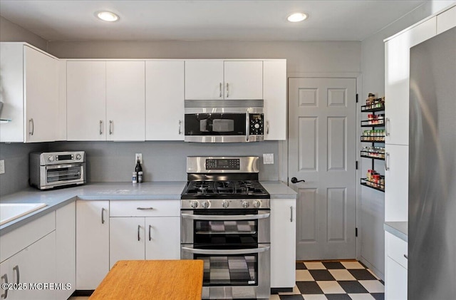 3100 Harrison St, Wall, NJ 07719 - kitchen featuring stainless steel appliances, tile patterned floors, light countertops, white cabinets, and recessed lighting