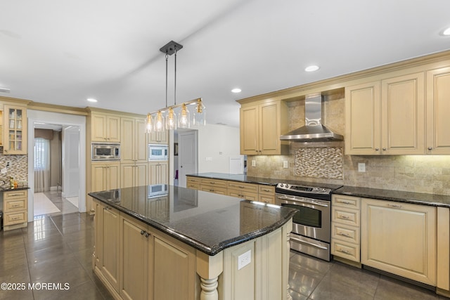 136 Sunset Rd, Lakewood, NJ 08701 - kitchen featuring wall chimney exhaust hood, stainless steel appliances, cream cabinets, backsplash, and dark tile patterned flooring