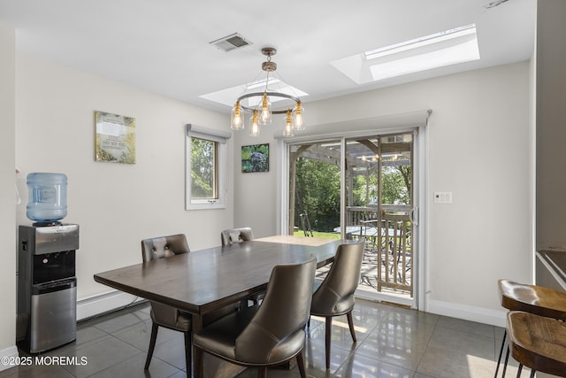 136 Sunset Rd, Lakewood, NJ 08701 - dining space featuring dark tile patterned flooring, a skylight, a baseboard heating unit, and a chandelier