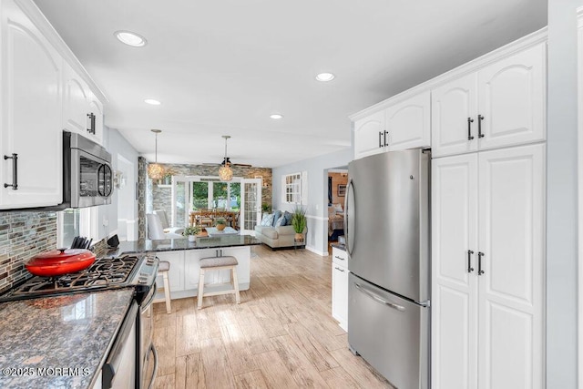 1 Cedar Ave, Rumson, NJ 07760 - kitchen featuring stainless steel appliances, white cabinets, recessed lighting, light wood finished floors, and backsplash