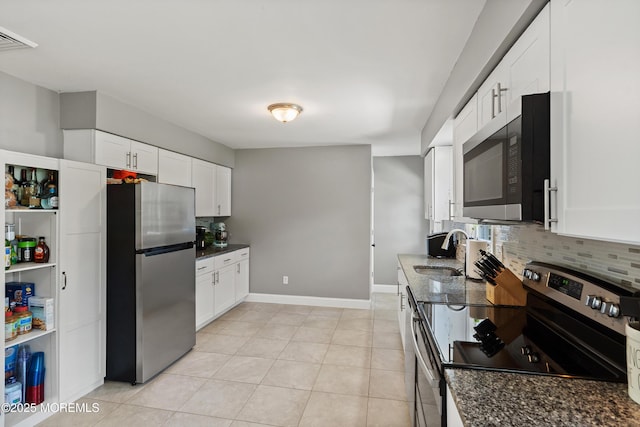 482 Radovan Ave, Bayville, NJ 08721 - kitchen featuring appliances with stainless steel finishes, dark stone counters, tasteful backsplash, and white cabinets