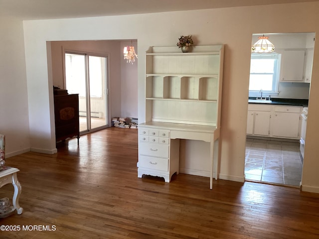 109 Edinburgh Ct, Toms River, NJ 08757 - unfurnished dining area with wood finished floors, a chandelier, and a baseboard radiator