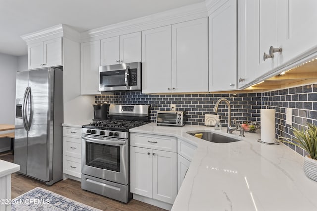 911 Beach Ave, Bradley Beach, NJ 07720 - kitchen with stainless steel appliances, white cabinets, backsplash, and light stone countertops