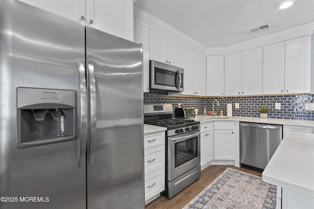 911 Beach Ave, Bradley Beach, NJ 07720 - kitchen with stainless steel appliances, light countertops, white cabinetry, and tasteful backsplash