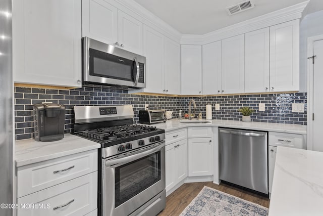 911 Beach Ave, Bradley Beach, NJ 07720 - kitchen with stainless steel appliances, white cabinetry, wood finished floors, backsplash, and light stone counters