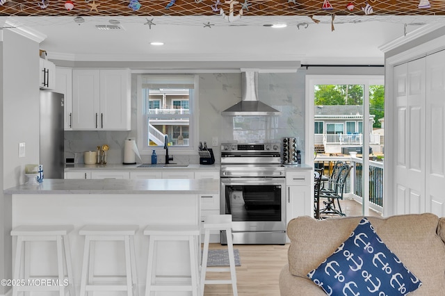 8 Navarra Dr, Brick, NJ 08723 - kitchen with stainless steel appliances, wall chimney exhaust hood, tasteful backsplash, white cabinetry, and crown molding