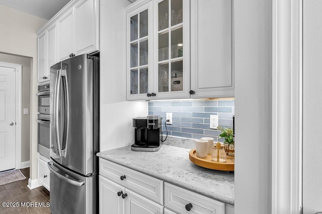 30 Malcolm Way, Lincroft, NJ 07738 - kitchen featuring freestanding refrigerator, glass insert cabinets, white cabinetry, decorative backsplash, and light stone counters