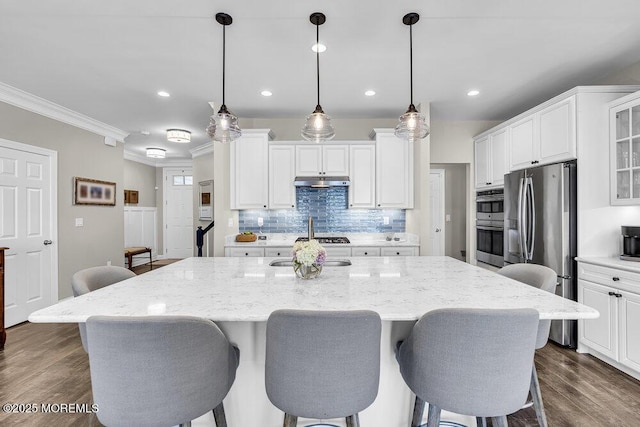 30 Malcolm Way, Lincroft, NJ 07738 - kitchen featuring ornamental molding, appliances with stainless steel finishes, a breakfast bar area, white cabinetry, and decorative backsplash