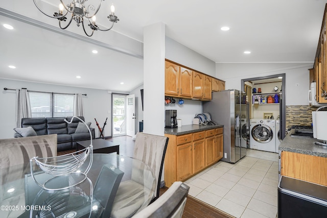 14 Cedar Ct, Manalapan, NJ 07726 - kitchen featuring washing machine and clothes dryer, open floor plan, dark countertops, a chandelier, and brown cabinetry