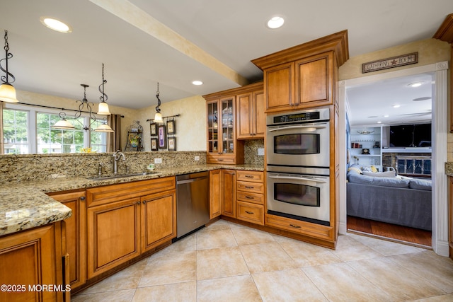 9 Partridge Ave, Freehold, NJ 07728 - kitchen with stainless steel appliances, brown cabinetry, light stone countertops, decorative backsplash, and glass insert cabinets
