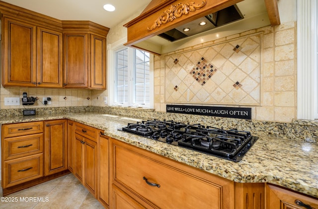 9 Partridge Ave, Freehold, NJ 07728 - kitchen with black gas stovetop, brown cabinets, tasteful backsplash, premium range hood, and light stone counters